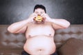 Obese male with cheeseburger and couch Royalty Free Stock Photo