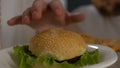 Obese male hesitating to take burger from fridge at night, will power choice