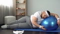 Obese male struggling to finish home workout program, fitness routine, goal