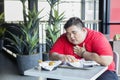 Obese person looks getting heart attack in cafe