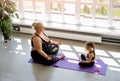 Obese Woman with daughter Doing Yoga, Meditation in lotus position Royalty Free Stock Photo