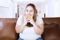 Obese woman with delicious cheeseburger at home