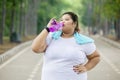 Obese woman drinking water after doing a workout