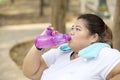 Obese woman drinks water after doing a workout Royalty Free Stock Photo