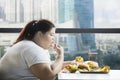 Obese woman eating french fries in the restaurant