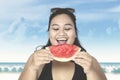 Obese woman eating watermelon on beach Royalty Free Stock Photo