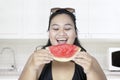 Obese woman eating watermelon in kitchen Royalty Free Stock Photo