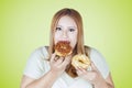 Obese woman eats two donuts Royalty Free Stock Photo