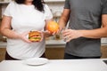 Obese woman with hamburger and trainer with fruits Royalty Free Stock Photo