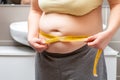 Obese woman measuring her waist at the bathroom Royalty Free Stock Photo