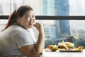 Smiling obese woman eating french fries in the cafe