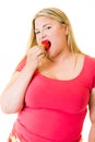 Obese young blond woman eating ripe strawberry