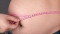 Obesity concept, measure a large fat belly with a centimeter