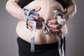 Obesity female body, fat woman with measuring tape