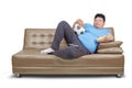 Obesity man lie on sofa and watch soccer game Royalty Free Stock Photo