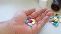Obesity patient take medicine colorful tablets, pills and capsules in hand for treatment and cure disease or sickness.