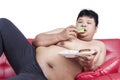 Obesity person eating donuts on sofa