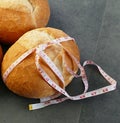Obesity and whole wheat bread, tape measure wrapped in a large bread Royalty Free Stock Photo