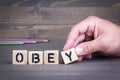 Obey from wooden letters on wooden background