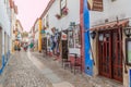 OBIDOS, PORTUGAL - OCTOBER 11, 2017: Tourists in a narrow alley in Obidos villag