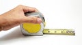 Object shot of a hand holding a tape measure isolated on a white background.