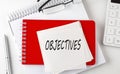 OBJECTIVES word on the sticker on notepad with pen and calculator