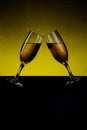 champagne glasses standing slanted on yellow background