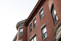 Oblique view of brick apartment building with rusticated stone window lintels and dentil trim details