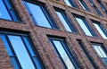 Oblique view on modern red brick stone facade with blue glass windows - Maastricht, Netherlands