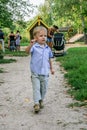 2010.08.15, Obninsk, Russia. Little boy running and jumping by the playground in the park.