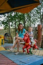 2010.08.15, Obninsk, Russia. A mother and a little boy spinning on a carousel horse and laughing.