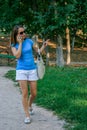 2010.08.15, Obninsk, Russia. Young woman walking in the park and speaking phone.