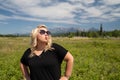 Obnoxious blonde woman does a duck face with pouting lips, hands on hips, in Glacier National Park, near Polebridge, Montana, in a