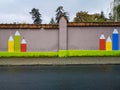 Brick fence of kindergarten with painted on colorful crayons