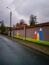 Brick fence of kindergarten with painted on colorful crayons