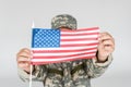 obscured view of kid in camouflage clothing showing american flagpole in hands Royalty Free Stock Photo