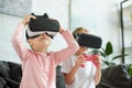 obscured view of kids in virtual reality headsets playing video game on sofa Royalty Free Stock Photo