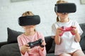 obscured view of kids in virtual reality headsets playing video game on sofa Royalty Free Stock Photo