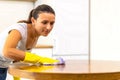 Close up photo of anxious girl polishing tabletop, making everything shine perfect, looking a major germophobe.