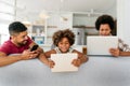 Obsessed to tech devices happy african american family using digital tablet, computer, smartphones