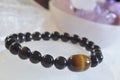 obsidian and tiger eye stone bracelet On selenite stone . Royalty Free Stock Photo