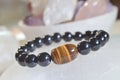 obsidian and tiger eye stone bracelet On selenite stone . Royalty Free Stock Photo