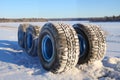 obsolete car wheels on the background of a winter snow-covered forest, beautiful landscape, a concept of traffic safety on a