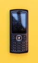 Obsolete mobile phone on a yellow background Royalty Free Stock Photo