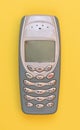 Obsolete mobile phone on a yellow background Royalty Free Stock Photo