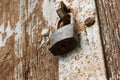 Obsolete rusty padlock on gates. A rusty lock hangs on the wooden door Royalty Free Stock Photo