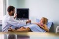 Obstetrician examining pregnant woman belly by ultrasonic scan in hospital. Royalty Free Stock Photo