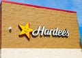 OCALA, FLORIDA USA - OCTOBER 14, 2023 Hardees sign blue sky background with white clouds. Yellow star with smiling smily face logo