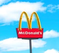 OCALA, FLORIDA USA - OCTOBER 14, 2023 McDonalds logo blue sky background with white clouds. Yellow golden arch iconic sign tall as