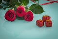 Occasional beautiful red roses with tiny boxes of gifts on the background